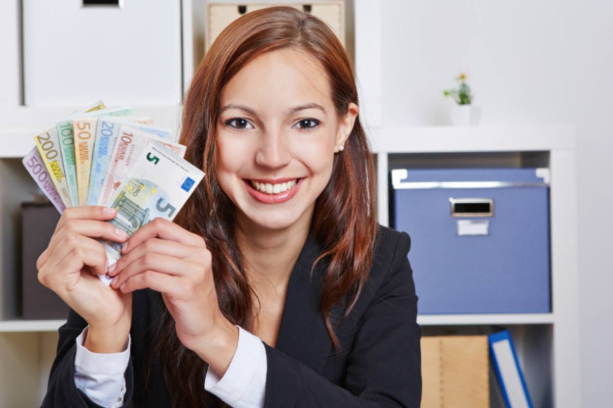 donna sorridente con tante banconote di euro in mano