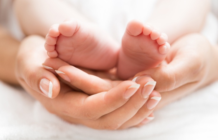 mani di donna e piedini di un neonato