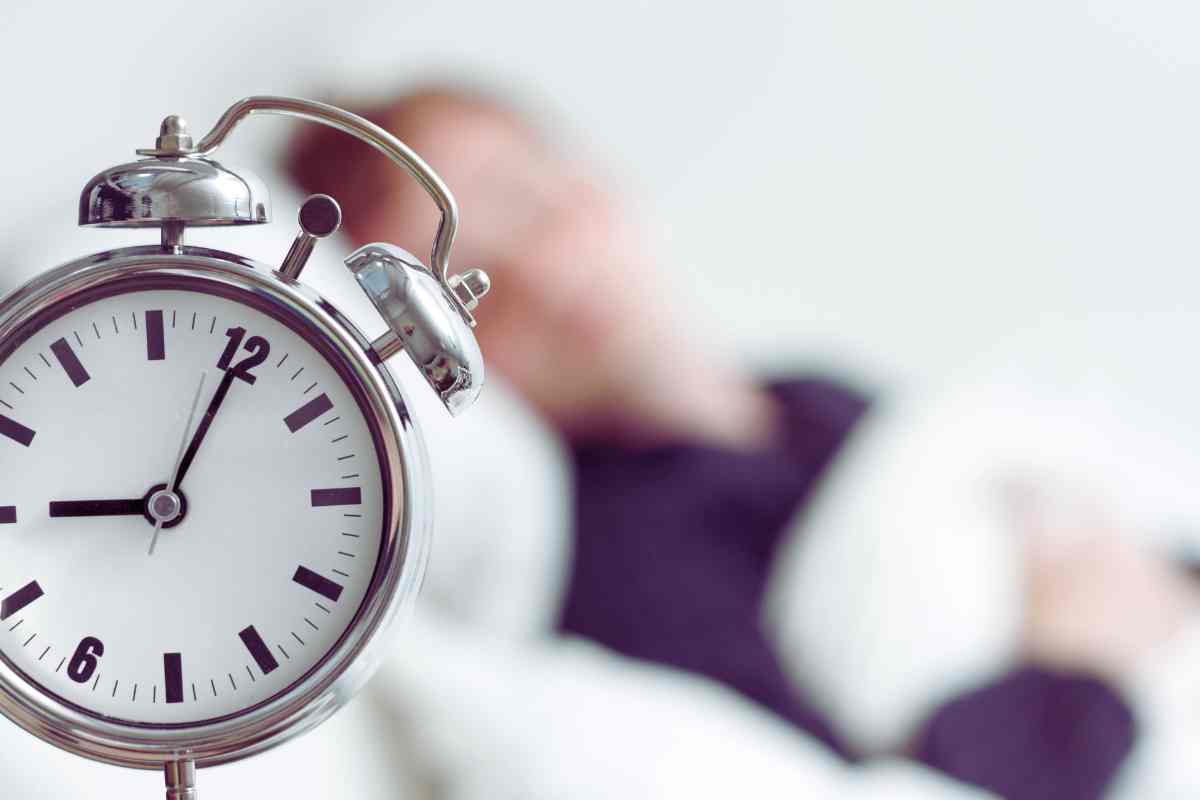 orologio con dietro persona che dorme