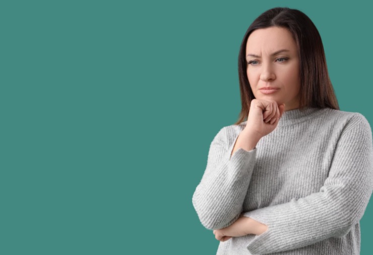 donna con espressione preoccupata e una mano sotto al mento