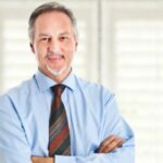 uomo che sorride con le braccia incrociate