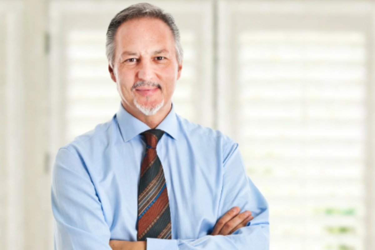 uomo che sorride con le braccia incrociate