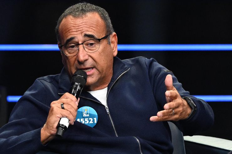 carlo conti con il microfono che parla