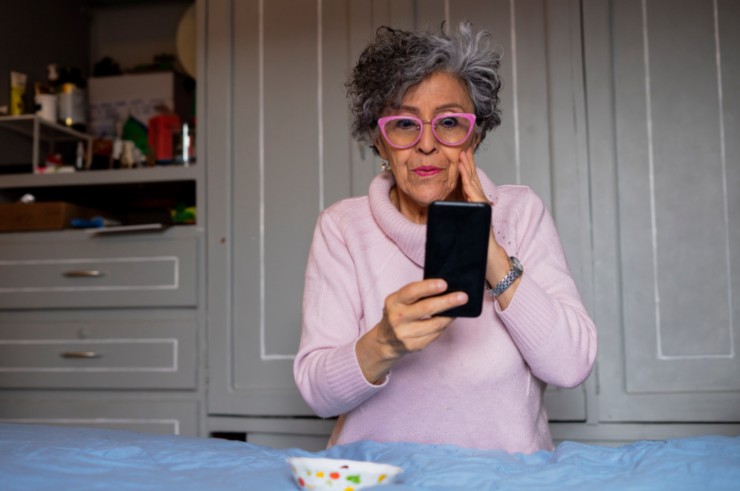 donna anziana che controlla il cellulare