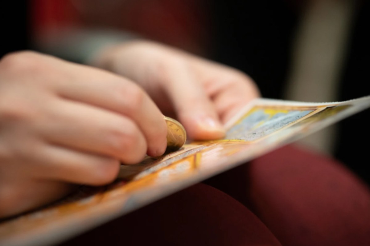 donna che gratta un tagliandino del gratta e vinci
