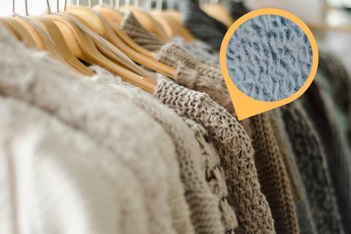 maglioni appesi su grucce di legno