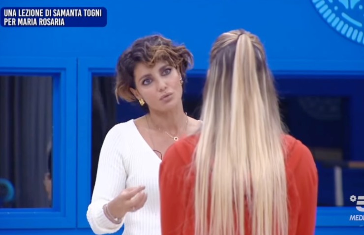 samanta togni mentre parla con maria rosaria di spalle