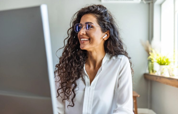 donna sorridente mentre lavora al computer