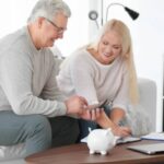 coppia di mezz'età con salvadanaio e calcolatrice